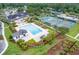Aerial view of a community pool and clubhouse with tennis courts, surrounded by lush landscaping and mature trees at 1020 Lyle Way, Mount Pleasant, SC 29466