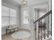 Bright entryway with a staircase, light wood floors, area rug, and a bench by a large window at 1020 Lyle Way, Mount Pleasant, SC 29466