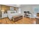 Spacious bedroom with wood accent wall, white bedding, light wood floors, desk, and patio access at 1048 Wharf Indigo Pl, Mount Pleasant, SC 29464