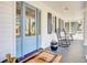 Close-up of a charming front porch, featuring classic rocking chairs and a welcoming blue front door at 1048 Wharf Indigo Pl, Mount Pleasant, SC 29464