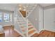 Staircase with wood steps, white railing, and decorative light fixtures at 1048 Wharf Indigo Pl, Mount Pleasant, SC 29464