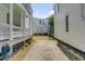 View down a concrete path between two homes to a grassy back yard and small building at 107 Bogard St, Charleston, SC 29403