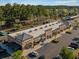This aerial view of commercial spaces shows ample parking, businesses, and is accented by trees and landscaping at 114 Belfort Pl, Summerville, SC 29486