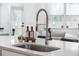 Close-up of a kitchen sink featuring a modern faucet, quartz countertops, and backyard view at 114 Belfort Pl, Summerville, SC 29486