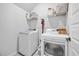 Well-lit laundry room with a white washer and dryer, wire shelving, and neutral-colored storage baskets at 114 Belfort Pl, Summerville, SC 29486