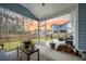 Screened porch overlooking backyard, featuring a table, woodpile, and view of the neighboring home at 114 Belfort Pl, Summerville, SC 29486