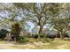 Expansive two-story home exterior with lush landscaping, brick foundation, and outdoor patio at 1429 Burningtree Rd, Charleston, SC 29412