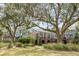 Expansive two-story home exterior with lush landscaping, brick foundation, and outdoor patio at 1429 Burningtree Rd, Charleston, SC 29412