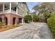 A two story home boasts a brick facade, grey siding, and a spacious driveway leading to multiple garages at 1429 Burningtree Rd, Charleston, SC 29412