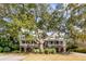 Charming two-story home with a large tree providing shade and a covered porch for enjoying the outdoors at 1429 Burningtree Rd, Charleston, SC 29412