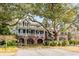 Two-story home with a covered porch, brick foundation, and manicured lawn, perfect for Gathering living at 1429 Burningtree Rd, Charleston, SC 29412