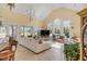 Large living room with high ceilings, chandeliers, expansive windows overlooking the yard and travertine floors at 1429 Burningtree Rd, Charleston, SC 29412