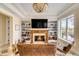 Cozy living room featuring a fireplace, built-in bookshelves, a large television, and leather furniture at 1429 Burningtree Rd, Charleston, SC 29412