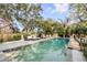 Backyard pool area with ample seating, blue umbrella, and lush surrounding greenery at 1429 Burningtree Rd, Charleston, SC 29412