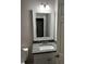 Bathroom featuring a vanity with a granite countertop, decorative mirror, and stylish lighting fixtures at 149 Rose Ave, Walterboro, SC 29488