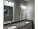 Bright bathroom featuring a double vanity with granite countertops and decorative framed mirrors at 149 Rose Ave, Walterboro, SC 29488