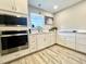 A modern kitchen with stainless steel appliances, bright lighting, and white cabinetry at 1545 Ashley River Rd # 3K, Charleston, SC 29407