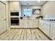 Well-lit kitchen with white cabinets, stainless steel appliances, and light wood grain flooring at 1545 Ashley River Rd # 3K, Charleston, SC 29407