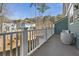 Relax on the covered balcony of this home with white railings and a peaceful view of the backyard and neighborhood at 1549 Moss Spring Rd, Mount Pleasant, SC 29466