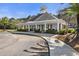 View of the clubhouse exterior featuring brick accents, white columns, and shade landscaping at 1549 Moss Spring Rd, Mount Pleasant, SC 29466