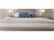 A close-up of the cozy king-size bed with plush pillows and a stylish bench at the foot in the main bedroom at 1549 Moss Spring Rd, Mount Pleasant, SC 29466
