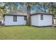View of the house from backyard with a grassy lawn, and mature trees at 1652 Larry St, North Charleston, SC 29405