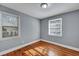 A bright bedroom with hardwood floors, two large windows and fresh, light gray paint at 1652 Larry St, North Charleston, SC 29405