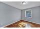 A simple bedroom features hardwood flooring, a window to let in natural light, and light gray paint at 1652 Larry St, North Charleston, SC 29405