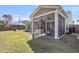 Screened in back porch with seating overlooking the backyard and adjacent home at 1855 Halle Rd, Johns Island, SC 29455