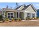 Charming single-story home featuring a covered porch, green siding, and well-maintained landscaping at 1855 Halle Rd, Johns Island, SC 29455