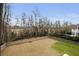 A vast backyard enclosed by a wooden fence, lined with tall trees and lush shrubbery at 1918 Essex Farms Dr, Charleston, SC 29414