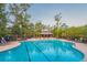 Spacious community pool area featuring a zero entry section, picnic tables, and sun loungers at 1918 Essex Farms Dr, Charleston, SC 29414