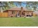 A beautiful backyard with a brick home, green grass, mature trees, and a privacy fence at 201 Maple Dr, Summerville, SC 29485