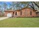Classic brick home featuring arched windows, a charming front porch, and an attached garage on a green lawn at 201 Maple Dr, Summerville, SC 29485