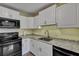 Functional kitchen featuring white cabinets, granite countertops, and black appliances, offering a modern cooking space at 201 Maple Dr, Summerville, SC 29485
