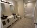 Modern bathroom featuring dual vessel sinks, granite countertops, and a shower-tub combo at 2100 Booker St, Charleston, SC 29405