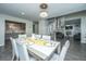 Bright dining room with white table set and chairs, decorative light fixture, and tiled floors at 240 Horseshoe Dr, Goose Creek, SC 29445