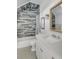 Well-lit bathroom featuring a tub-shower combo with stylish tile surround and a decorative mirror at 3001 Marshall Blvd, Sullivans Island, SC 29482