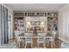 Dining room with decorative shelving opens to a modern kitchen with barstool seating at the island at 3001 Marshall Blvd, Sullivans Island, SC 29482