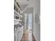Hallway with built-in bookshelves leading to a bright sitting area with ocean views at 3001 Marshall Blvd, Sullivans Island, SC 29482