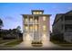 Two-story home showcasing a charming exterior with double balconies, complemented by a well-maintained front yard and garage at 325 Blowing Fresh Dr, Charleston, SC 29492