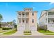 Charming two-story beach home with double garages, covered decks, and a welcoming entryway at 325 Blowing Fresh Dr, Charleston, SC 29492