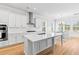 Spacious kitchen with stainless steel appliances and a large island with seating and adjacent dining area at 325 Blowing Fresh Dr, Charleston, SC 29492
