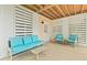 Stylish covered patio with turquoise cushioned furniture, plank ceiling, and a private outdoor retreat at 325 Blowing Fresh Dr, Charleston, SC 29492