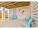 Covered patio featuring comfortable turquoise cushioned seating and a wooden plank ceiling at 325 Blowing Fresh Dr, Charleston, SC 29492