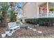 Landscaped backyard with a white bench, stepping stones, and mature trees at 3271 Johnstowne St, Johns Island, SC 29455
