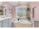 Pink bathroom features a soaking tub and decorative plants at 3271 Johnstowne St, Johns Island, SC 29455