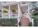 Welcoming front porch with ample seating, hanging plants, and stairs with brick trim at 3271 Johnstowne St, Johns Island, SC 29455
