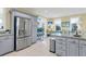 Open concept kitchen with stainless steel refrigerator, gray cabinets, and breakfast bar at 3271 Johnstowne St, Johns Island, SC 29455