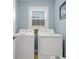 A laundry room features a washer and dryer with a window and light blue walls at 3271 Johnstowne St, Johns Island, SC 29455